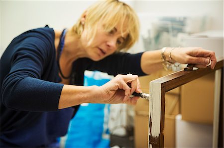 simsearch:6118-08659688,k - A woman working on a wooden frame with a paintbrush, upcycling wooden objects. Stockbilder - Premium RF Lizenzfrei, Bildnummer: 6118-09059802