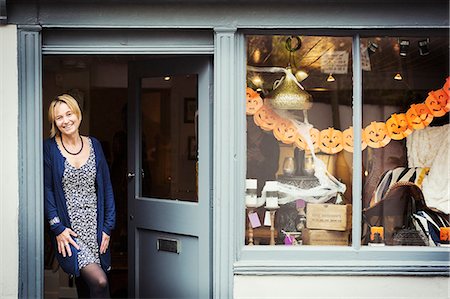 recycled - A woman standing in the doorway of her pop up interior design shop with a window display of objects. Stock Photo - Premium Royalty-Free, Code: 6118-09059804