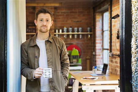 simsearch:6118-09059818,k - A young man standing at a workshop door, holding a coffee cup. Stock Photo - Premium Royalty-Free, Code: 6118-09059821