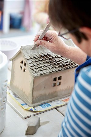 stanley knife - A woman potter using a small shaping tool to create the roof details for a clay model of a house. Stock Photo - Premium Royalty-Free, Code: 6118-09059828