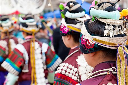 Rear view of girls wearing colourful traditional Chinese costumes and headdresses dancing at a festival. Foto de stock - Sin royalties Premium, Código: 6118-09076443