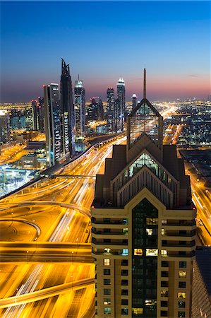 simsearch:841-07653291,k - Cityscape with illuminated skyscrapers and light trails on highways at dusk. Stock Photo - Premium Royalty-Free, Code: 6118-09076467