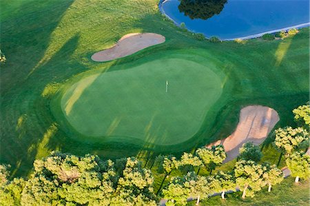 simsearch:851-02962928,k - Aerial view of a golf course with lush green lawn, trees and bunkers. Foto de stock - Sin royalties Premium, Código: 6118-09076407