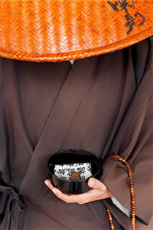Close up of Japanese monk wearing traditional clothing holding alms bowl. Stock Photo - Premium Royalty-Free, Code: 6118-09076581