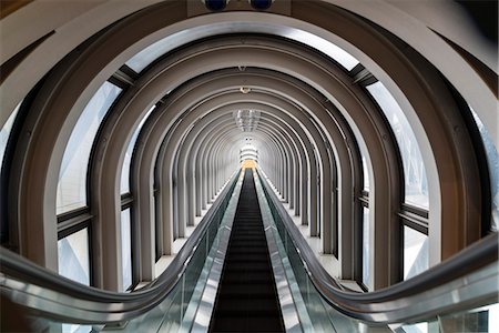 stairs on tunnel - Interior view of contemporary building with escalator running across glass atrium with arched ceiling. Stock Photo - Premium Royalty-Free, Code: 6118-09076591