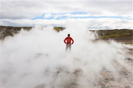 simsearch:6118-09076554,k - Rear view of woman standing by geothermal pools, surrounded by steam. Photographie de stock - Premium Libres de Droits, Code: 6118-09076535