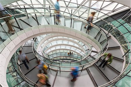 spiral - Interior view of building with people walking along glass and metal spiral staircase. Stock Photo - Premium Royalty-Free, Code: 6118-09076617