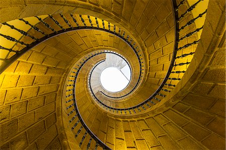 santiago de compostela - Low angle view of stone spiral staircase towards skylight. Stock Photo - Premium Royalty-Free, Code: 6118-09076702