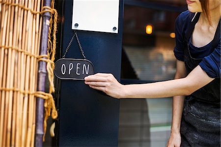 fermer - Close up of woman turning open sign on glass door to a bakery. Photographie de stock - Premium Libres de Droits, Code: 6118-09079275