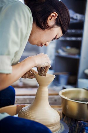 simsearch:614-08684981,k - Woman working in a Japanese porcelain workshop, sitting at a potter's wheel, throwing bowl. Stock Photo - Premium Royalty-Free, Code: 6118-09079422