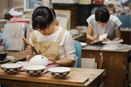 simsearch:6118-08659688,k - Woman working in a Japanese porcelain workshop, painting geometric pattern onto white bowls with paintbrush. Stockbilder - Premium RF Lizenzfrei, Bildnummer: 6118-09079436