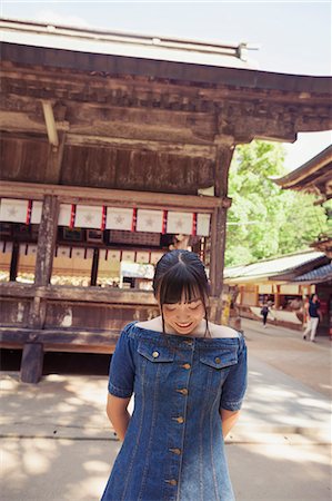 simsearch:6118-09079564,k - Young woman wearing blue dress standing at Shinto Sakurai Shrine, Fukuoka, Japan. Fotografie stock - Premium Royalty-Free, Codice: 6118-09079540