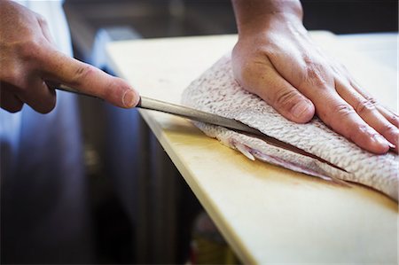 simsearch:6118-09079597,k - High angle close up of chef working at a counter at a Japanese sushi restaurant, slicing fillet of fish. Stock Photo - Premium Royalty-Free, Code: 6118-09079599