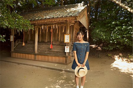 simsearch:6118-09079556,k - Young woman wearing blue dress and holding hat standing at Shinto Sakurai Shrine, Fukuoka, Japan. Foto de stock - Sin royalties Premium, Código: 6118-09079538