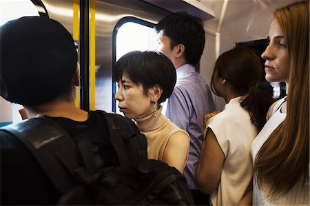 simsearch:841-08102240,k - Small group of people standing on a subway train, Tokyo commuters. Photographie de stock - Premium Libres de Droits, Code: 6118-09079685