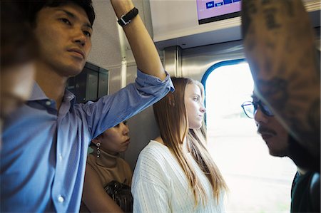 Small group of people standing on a subway train, Tokyo commuters. Stock Photo - Premium Royalty-Free, Code: 6118-09079689