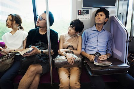 simsearch:841-03676982,k - Four people sitting sidy by side on a subway train, Tokyo commuters. Photographie de stock - Premium Libres de Droits, Code: 6118-09079693