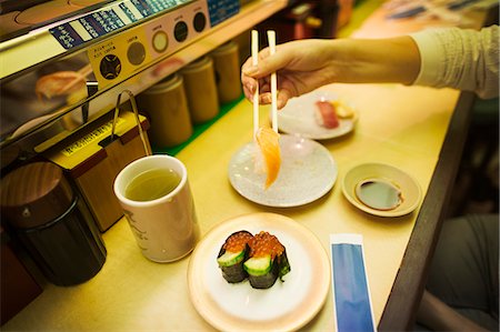 simsearch:6118-09079717,k - High angle close up of person eating in a sushi bar, with sushi train, Kaiten-zushi. Stock Photo - Premium Royalty-Free, Code: 6118-09079697