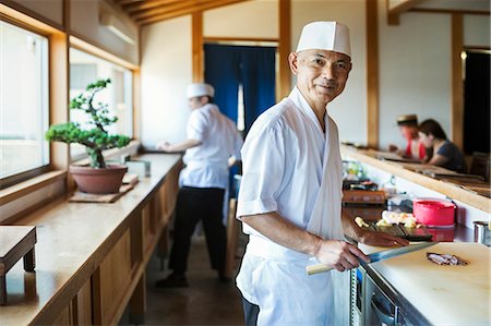 Two chefs working at a counter at a Japanese sushi restaurant. Photographie de stock - Premium Libres de Droits, Code: 6118-09079629