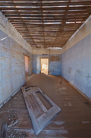 A view of a room in a derelict building full of sand. Stock Photo - Premium Royalty-Free, Code: 6118-09018134