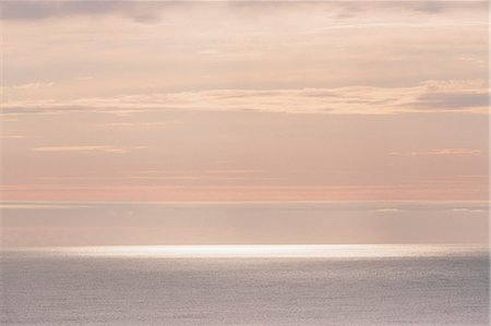 sunlight abstract - View from the land over the ocean, to the horizon. Pink and pastel colours in the sky, clouds tinged by sunlight. Stock Photo - Premium Royalty-Free, Code: 6118-09018251