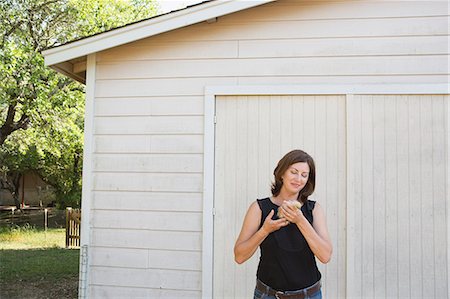 simsearch:6118-09018327,k - A woman holding a small fluffy chick, a baby bird in her two hands. Photographie de stock - Premium Libres de Droits, Code: 6118-09018327