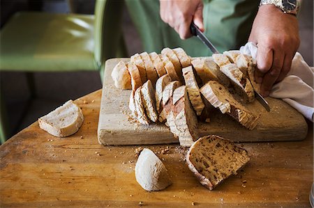 simsearch:614-03903601,k - Close up high angle view of person slicing freshly baked loaf of bread. Stockbilder - Premium RF Lizenzfrei, Bildnummer: 6118-09018423