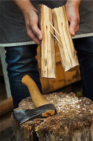 simsearch:6118-08947795,k - Close up of a person holding small log of wood split in half and a hand axe resting on a splitting block Stock Photo - Premium Royalty-Free, Code: 6118-09018577