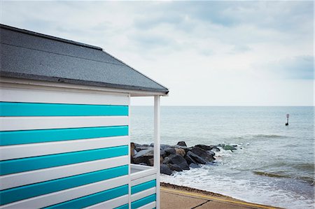 strandhütte - A blue and white striped painted beach hut on a beach on the coast. Stockbilder - Premium RF Lizenzfrei, Bildnummer: 6118-09018643