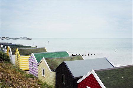 simsearch:400-05881319,k - Row of colourful huts on a sandy beach under a cloudy sky. Stockbilder - Premium RF Lizenzfrei, Bildnummer: 6118-09018640