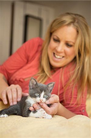 simsearch:6102-08951860,k - A woman with a small grey and white kitten. Stock Photo - Premium Royalty-Free, Code: 6118-09018674