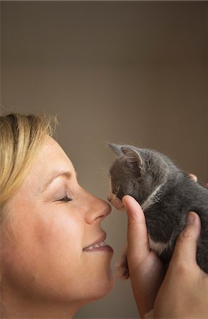 simsearch:6118-09018684,k - A woman holding a small grey kitten up to her face and touching noses. Foto de stock - Sin royalties Premium, Código: 6118-09018678