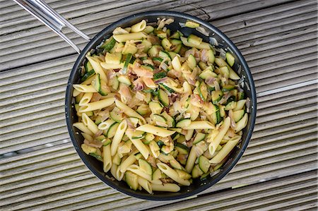 penis day - High angle close up of a pan of Penne pasta with onions and courgettes. Photographie de stock - Premium Libres de Droits, Code: 6118-09028098