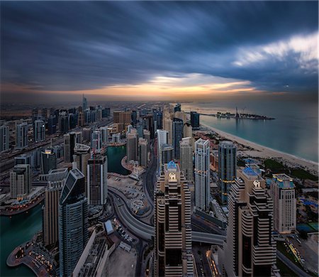 simsearch:841-03034485,k - Cityscape of Dubai, United Arab Emirates at dusk, with skyscrapers lining coastline of the Persian Gulf. Stock Photo - Premium Royalty-Free, Code: 6118-09028175