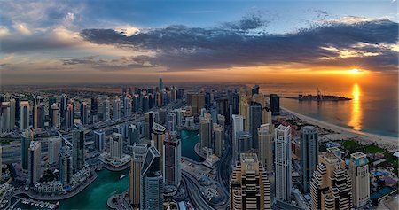 simsearch:649-07710300,k - Cityscape of Dubai, United Arab Emirates at dusk, with skyscrapers lining coastline of the Persian Gulf. Stock Photo - Premium Royalty-Free, Code: 6118-09028176