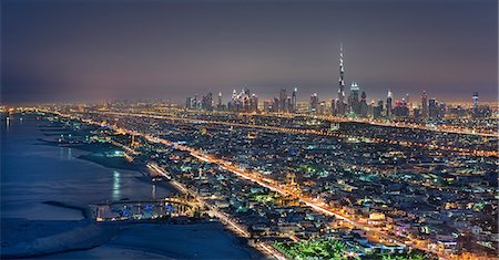 simsearch:841-03034485,k - Cityscape of Dubai, United Arab Emirates at dusk, with skyscrapers lining coastline of the Persian Gulf. Stock Photo - Premium Royalty-Free, Code: 6118-09028178