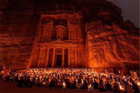 simsearch:6119-08518029,k - Exterior view of the rock-cut architecture of Al Khazneh or The Treasury at Petra, Jordan with large group of people sitting on the ground at night. Photographie de stock - Premium Libres de Droits, Code: 6118-09028129
