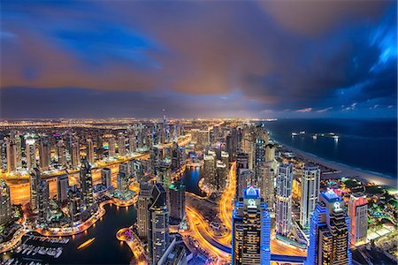 simsearch:841-03034485,k - Cityscape of the Dubai, United Arab Emirates at dusk, with illuminated skyscrapers and coastline of the Persian Gulf. Stock Photo - Premium Royalty-Free, Code: 6118-09028211