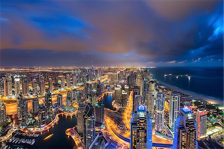 simsearch:649-07710300,k - Cityscape of the Dubai, United Arab Emirates at dusk, with illuminated skyscrapers and coastline of the Persian Gulf. Stock Photo - Premium Royalty-Free, Code: 6118-09028211