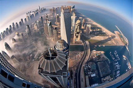 Aerial view of cityscape with skyscrapers above the clouds in Dubai, United Arab Emirates. Stock Photo - Premium Royalty-Free, Code: 6118-09028223