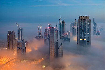 Cityscape with illuminated skyscrapers above the clouds in Dubai, United Arab Emirates. Stock Photo - Premium Royalty-Free, Code: 6118-09028228