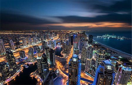 simsearch:649-08632842,k - Cityscape of the Dubai, United Arab Emirates at dusk, with illuminated skyscrapers and coastline of the Persian Gulf. Stock Photo - Premium Royalty-Free, Code: 6118-09028238