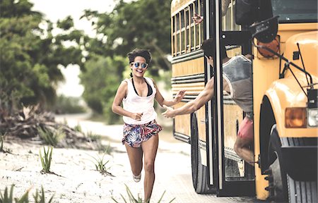 summer and fun and teenagers - A young woman chasing after a moving school bus. Stock Photo - Premium Royalty-Free, Code: 6118-09039097