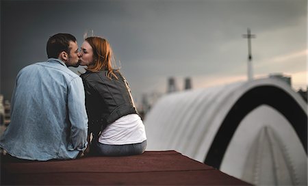 simsearch:6118-09039292,k - A couple sitting and kissing on a city rooftop. Foto de stock - Sin royalties Premium, Código: 6118-09039171