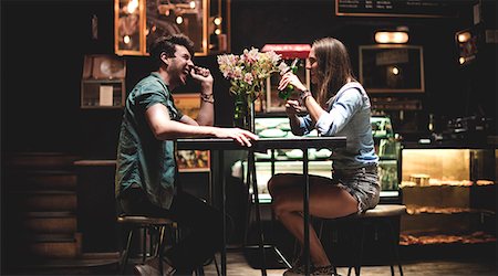 Two young people sitting at a table in a bar. Foto de stock - Sin royalties Premium, Código: 6118-09039211