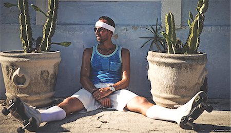 sweaty man - A man sitting down leaning against a wall between cacti growing in pots. Foto de stock - Sin royalties Premium, Código: 6118-09039232