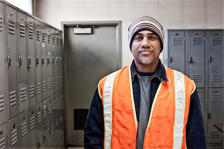 Black man factory worker standing next to lockers in a factory break room. Stock Photo - Premium Royalty-Free, Code: 6118-09140048