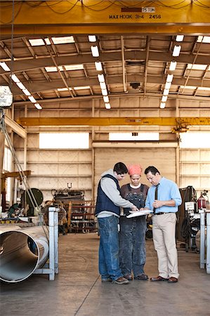 factory workers in usa - Mixed race team of workers and management people in a large sheet metal factory Stock Photo - Premium Royalty-Free, Code: 6118-09140087