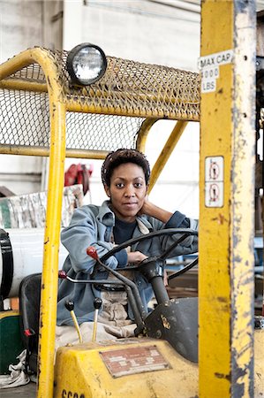 Black woman factory worker and a fork lift in a sheet metal factory. Stock Photo - Premium Royalty-Free, Code: 6118-09140096