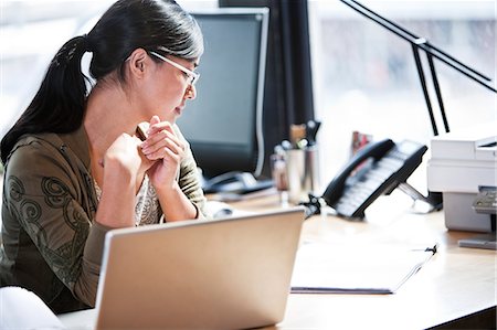 simsearch:6118-09139986,k - Asian woman working at her desk in a creative office. Foto de stock - Sin royalties Premium, Código: 6118-09140013